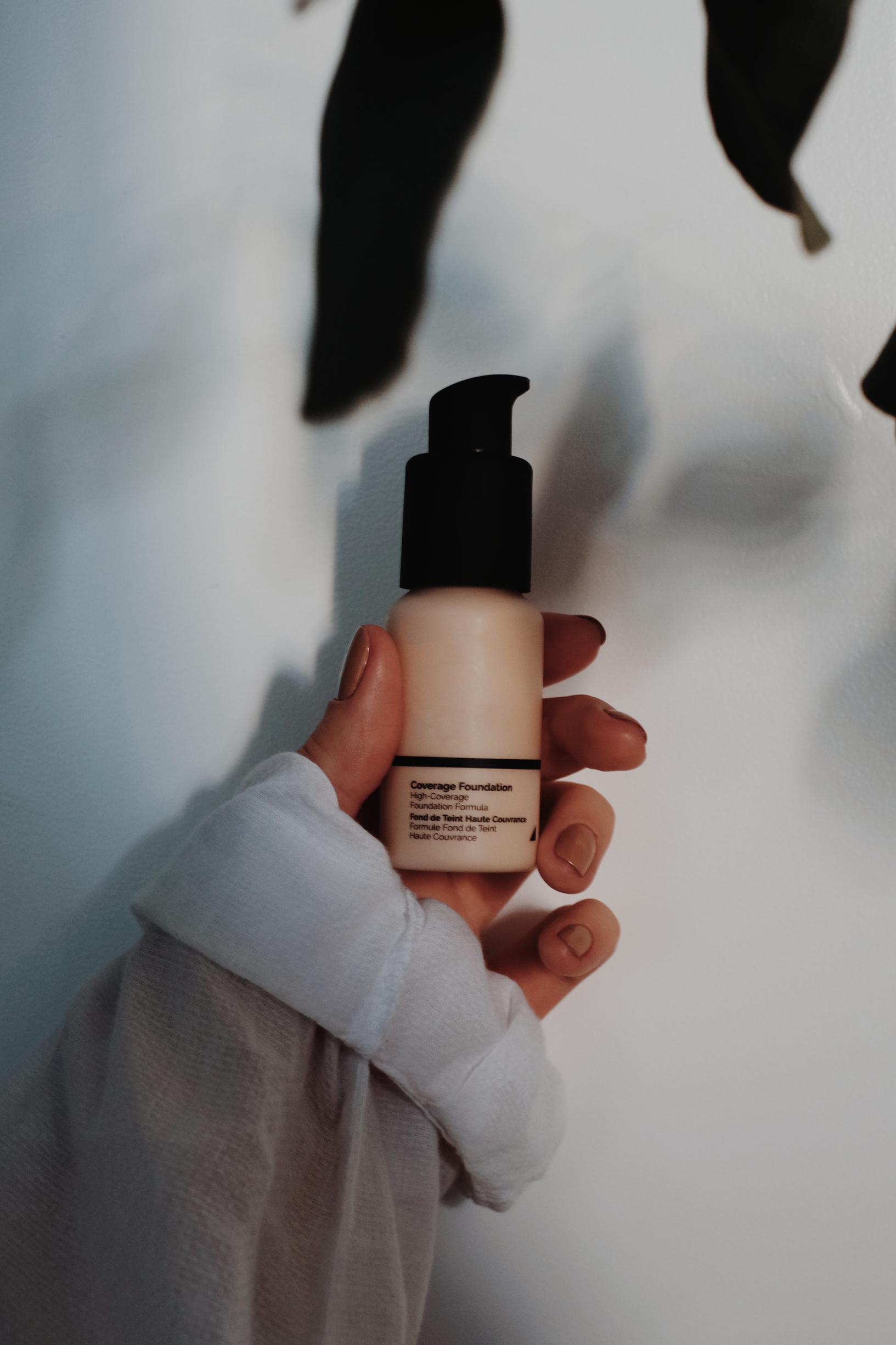 Woman holding beauty product in pump bottle